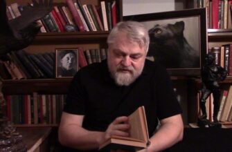 По центру Меняйлов с книгой, с лева статуэтка Орла, с права статуэтка Дон Кихота